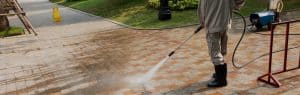 man cleaning patio with a pressure washer